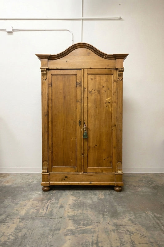 Antique pine armoire with arched bonnet top, carved columns and bun feet