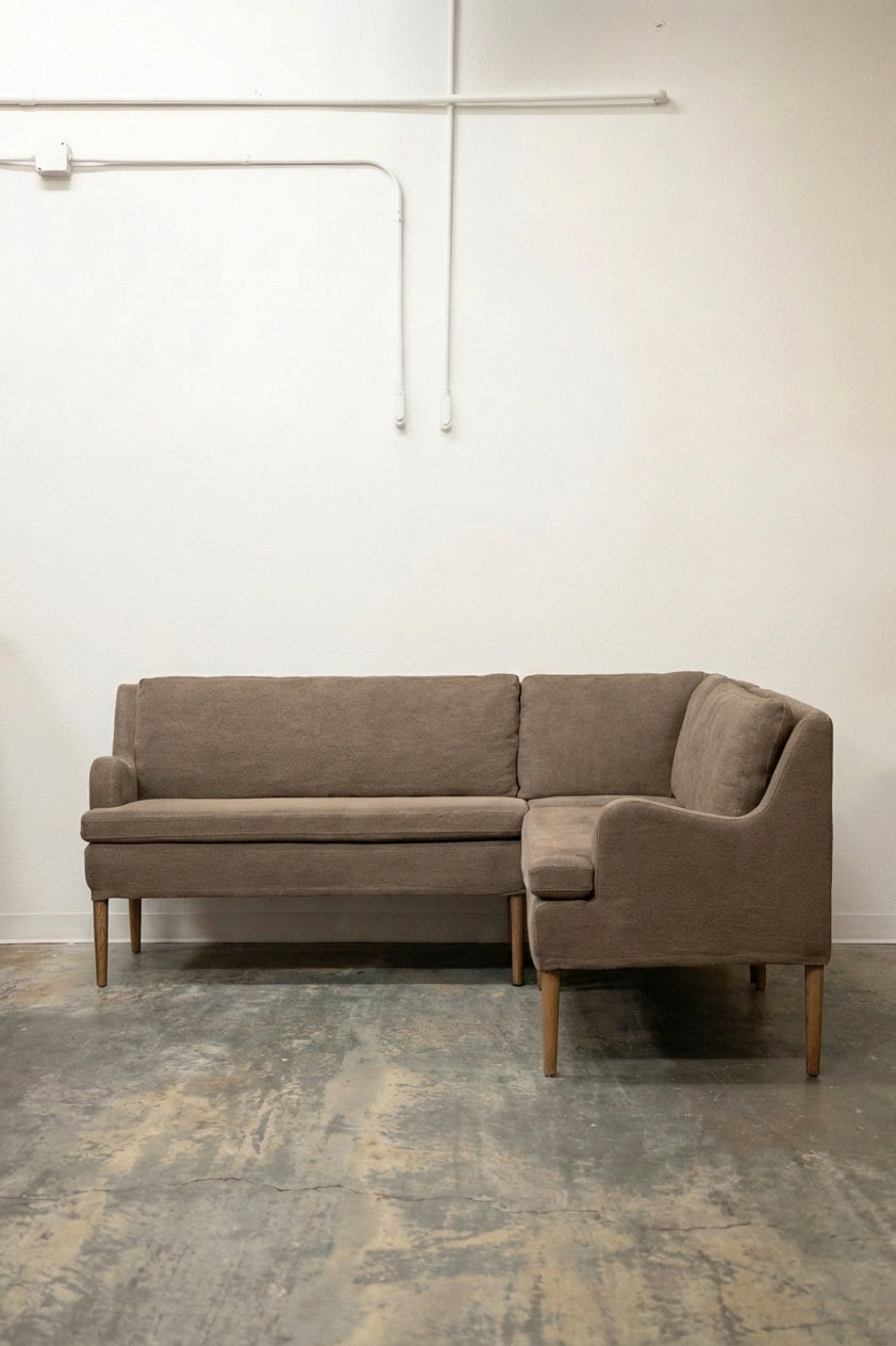 Mid-century modern L-shaped sectional sofa in taupe boucle fabric with tapered oak legs